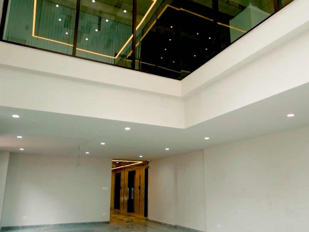 Double-height ground-floor lobby with glass atrium at Prasiddhi Towers